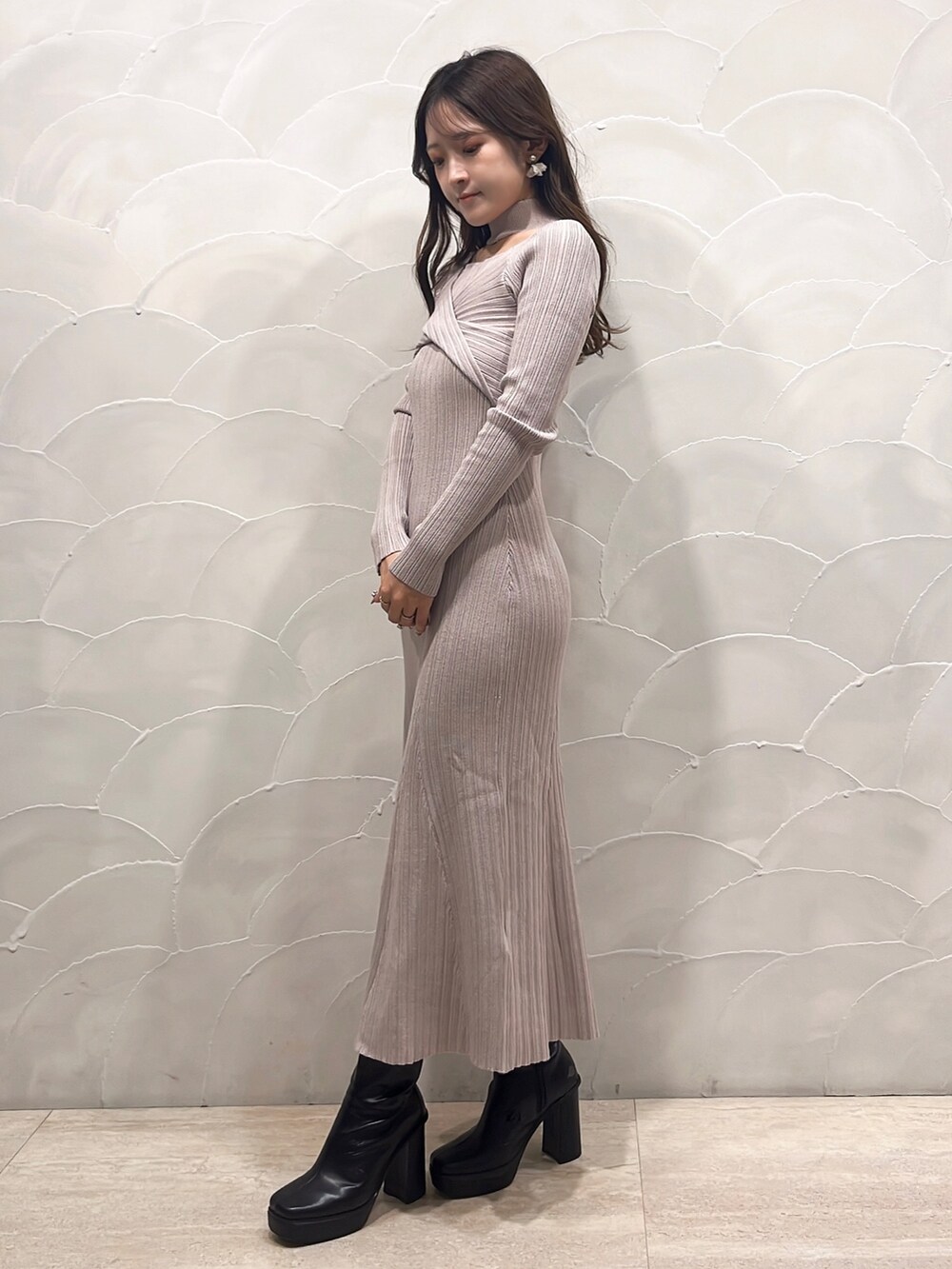 ベージュ系のワンピース、ブラック系のライダースジャケット、ブラック系のブーツを着用したレディースの秋コーディネートの5枚目の写真