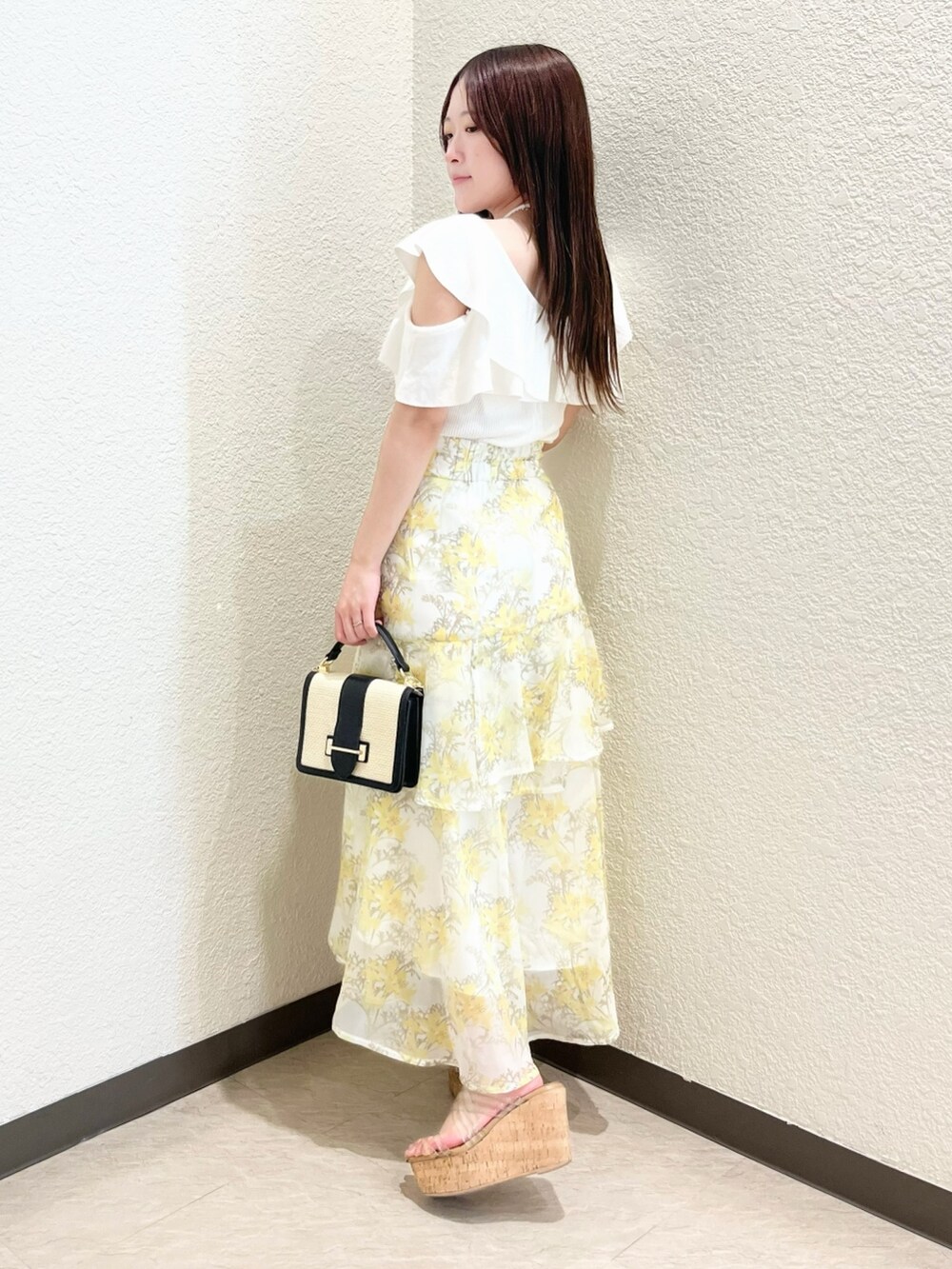 ホワイト系のニット/セーター、イエロー系のスカート、その他のサンダルを着用したレディースの春コーディネートの2枚目の写真
