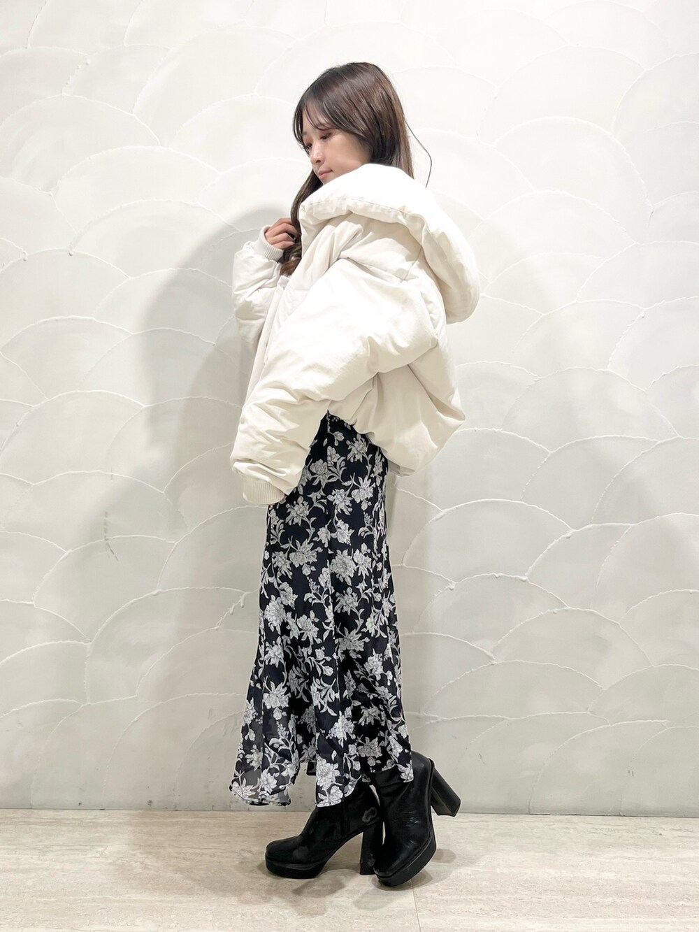 ホワイト系のダウンジャケット/コート、グレー系のスカート、グレー系のニット/セーターを着用したレディースの冬コーディネートの2枚目の写真