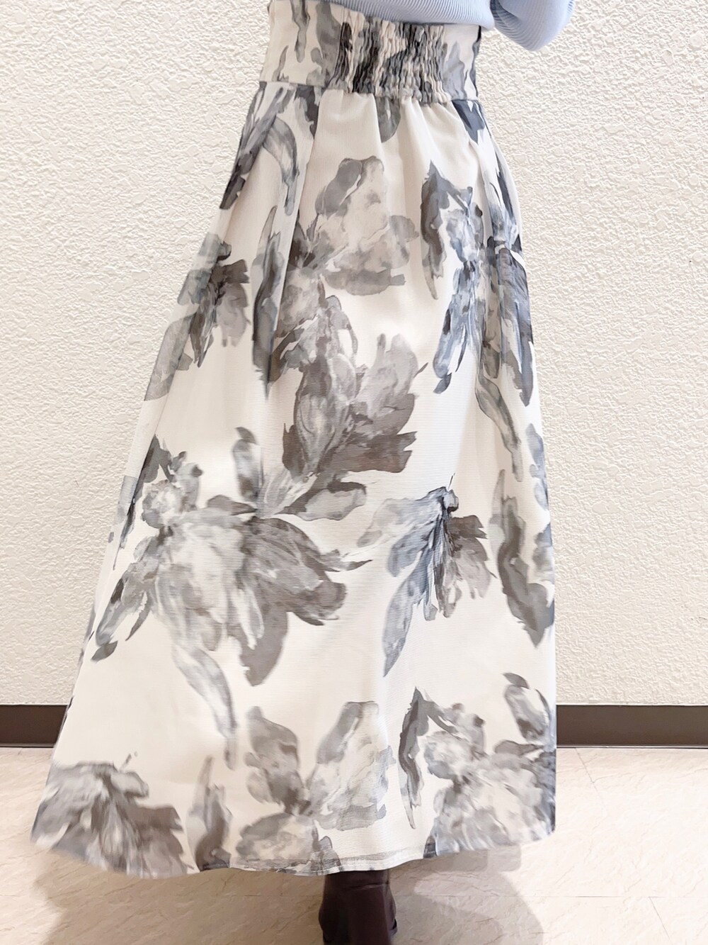 ホワイト系のスカート、ベージュ系のライダースジャケット、ブルー系のニット/セーターを着用したレディースの冬コーディネートの4枚目の写真