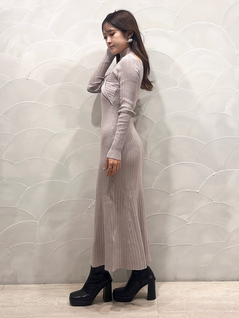 ベージュ系のワンピース、ブラック系のライダースジャケット、ブラック系のブーツを着用したレディースの秋コーディネートの3枚目の写真