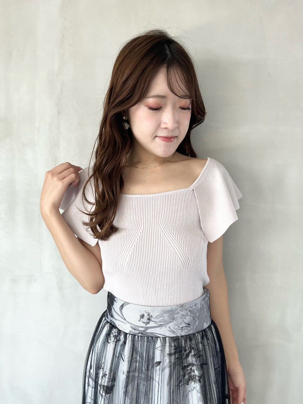 ブラック系のスカート、ピンク系のニット/セーター、ブラウン系のブーツを着用したレディースの春コーディネートの4枚目の写真