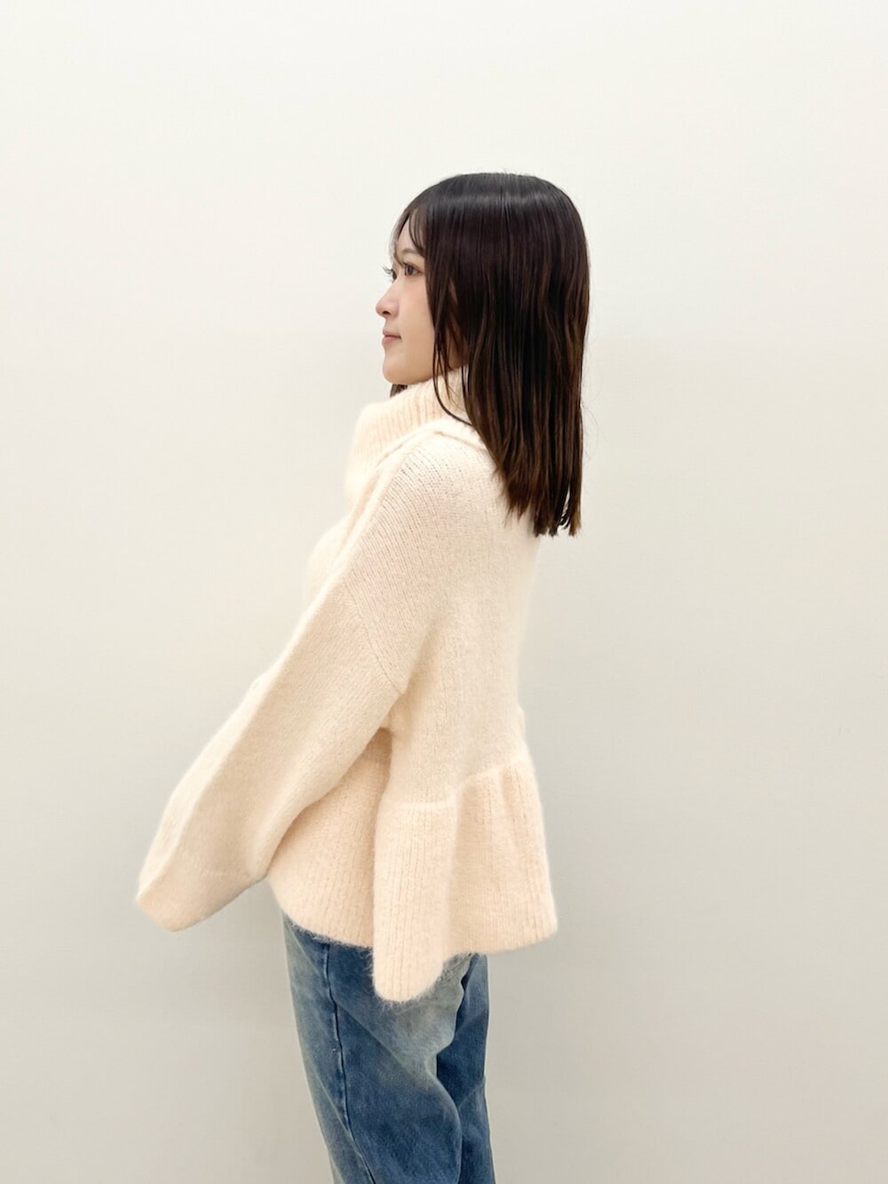 ピンク系のニット/セーター、ブルー系のデニムパンツを着用したレディースの秋コーディネートの5枚目の写真