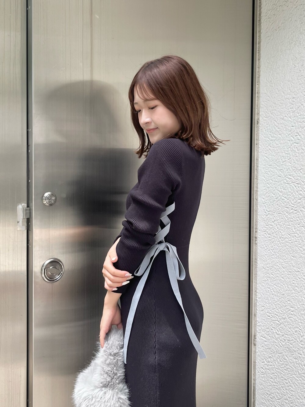 ブルー系のワンピース、グレー系のハンドバッグ、ホワイト系のブーツを着用したレディースの夏コーディネートの5枚目の写真