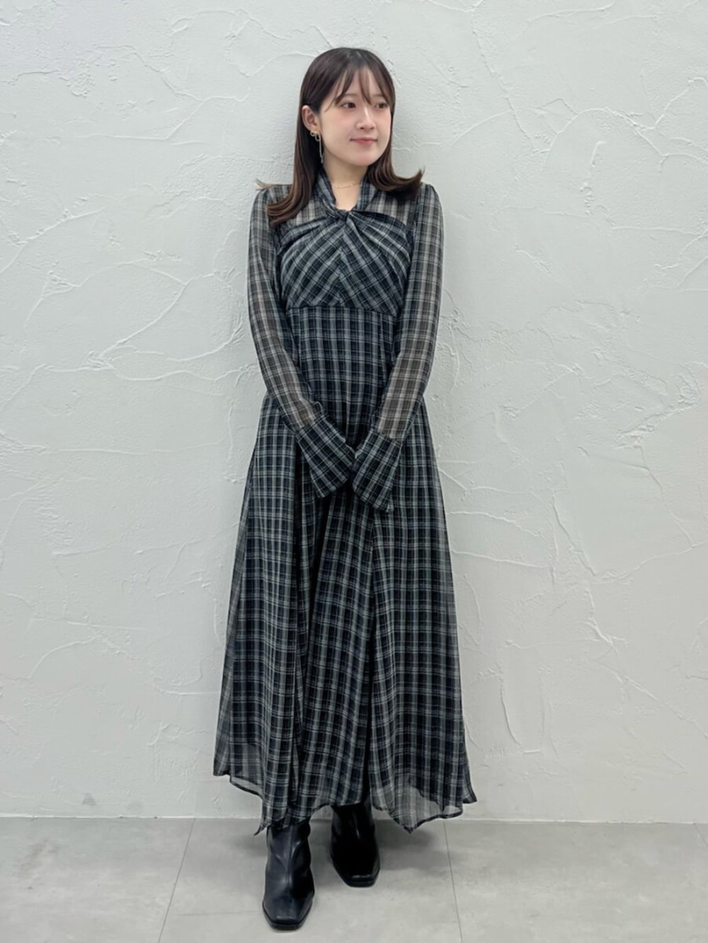 ブラック系のブーツ、ピンク系のカーディガン/ボレロ、ブラック系のワンピースを着用したレディースの秋コーディネートの3枚目の写真