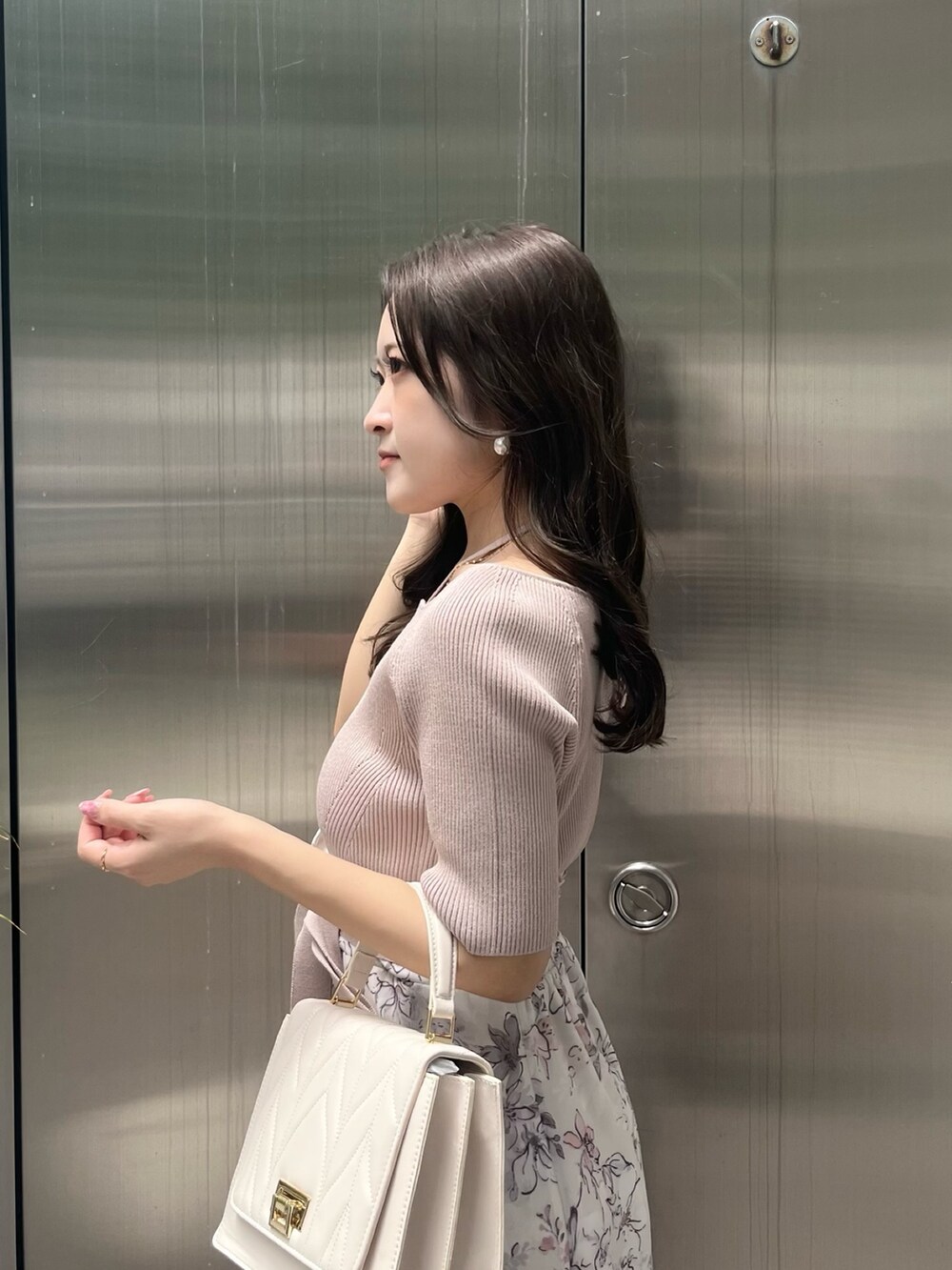 ベージュ系のワンピース、ホワイト系のショルダーバッグ、ホワイト系のブーツを着用したレディースの夏コーディネートの5枚目の写真