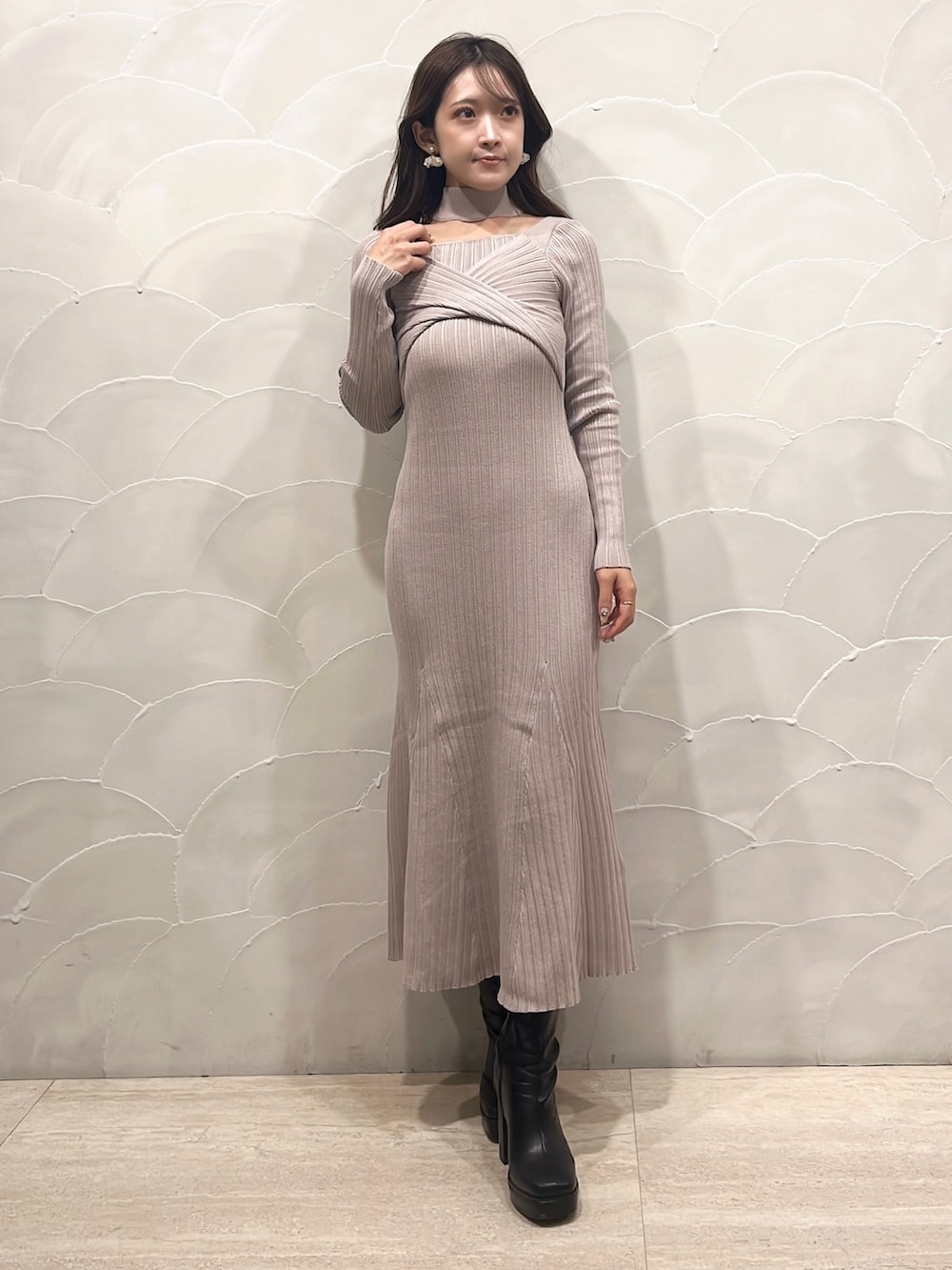 ベージュ系のワンピース、ブラック系のライダースジャケット、ブラック系のブーツを着用したレディースの秋コーディネートの4枚目の写真