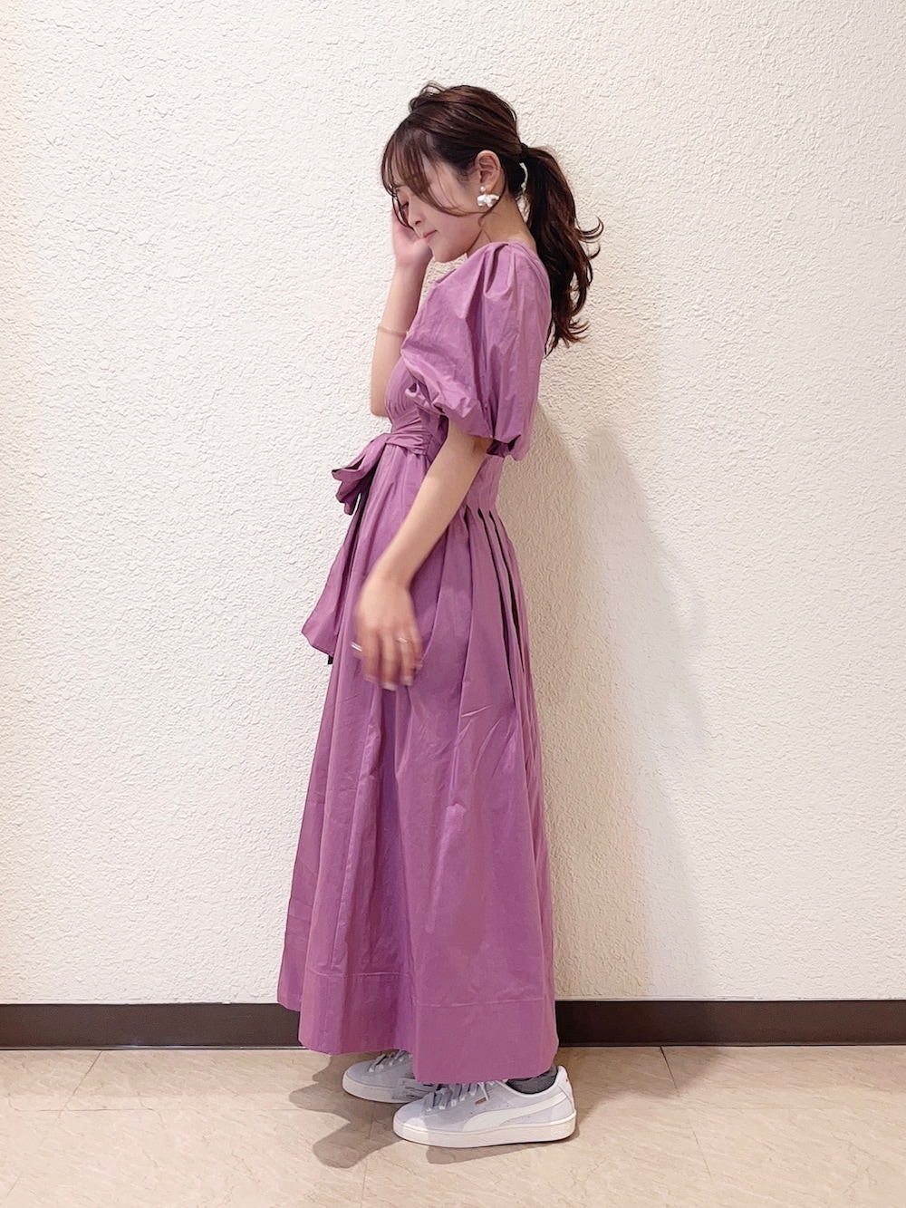 パープル系のワンピース、グレー系のスニーカーを着用したレディースの春コーディネートの2枚目の写真