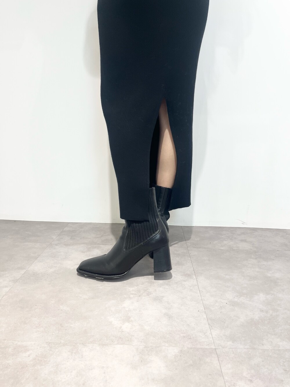 ブラック系のワンピース、ブラック系のショルダーバッグ、ブラック系のブーツを着用したレディースの冬コーディネートの7枚目の写真