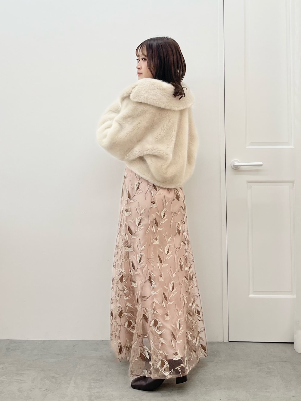 ピンク系のスカート、ホワイト系のニット/セーター、ホワイト系のその他アウターを着用したレディースの秋コーディネートの3枚目の写真