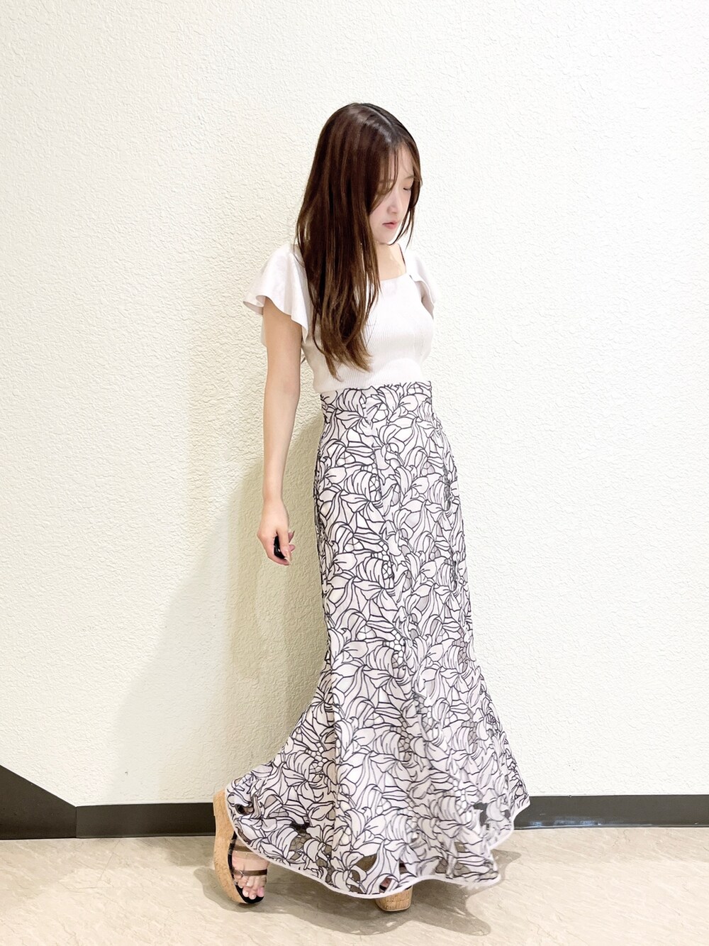 ピンク系のニット/セーター、ベージュ系のスカート、ブラック系のサンダルを着用したレディースの夏コーディネートの7枚目の写真