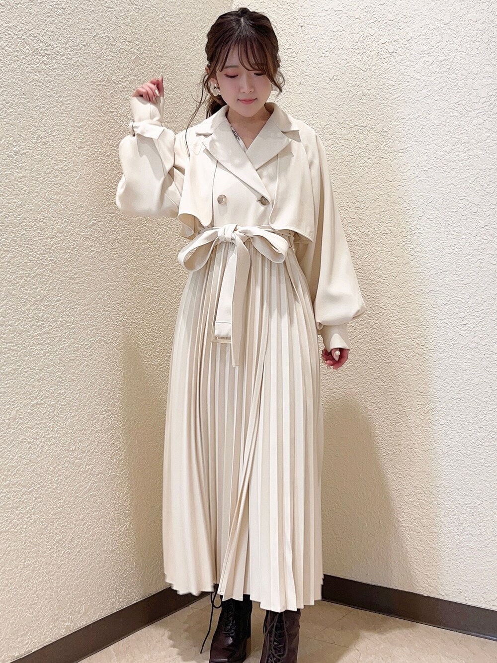 ホワイト系のトレンチコート、ホワイト系のワンピースを着用したレディースの冬コーディネートの2枚目の写真