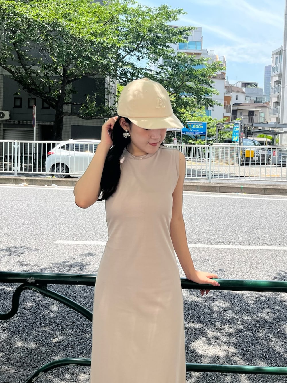 ベージュ系のスニーカー、ベージュ系のワンピース、ベージュ系のキャップを着用したレディースの夏コーディネートの7枚目の写真