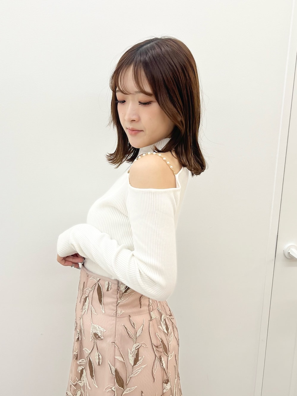 ピンク系のスカート、ホワイト系のニット/セーター、ホワイト系のその他アウターを着用したレディースの秋コーディネートの5枚目の写真