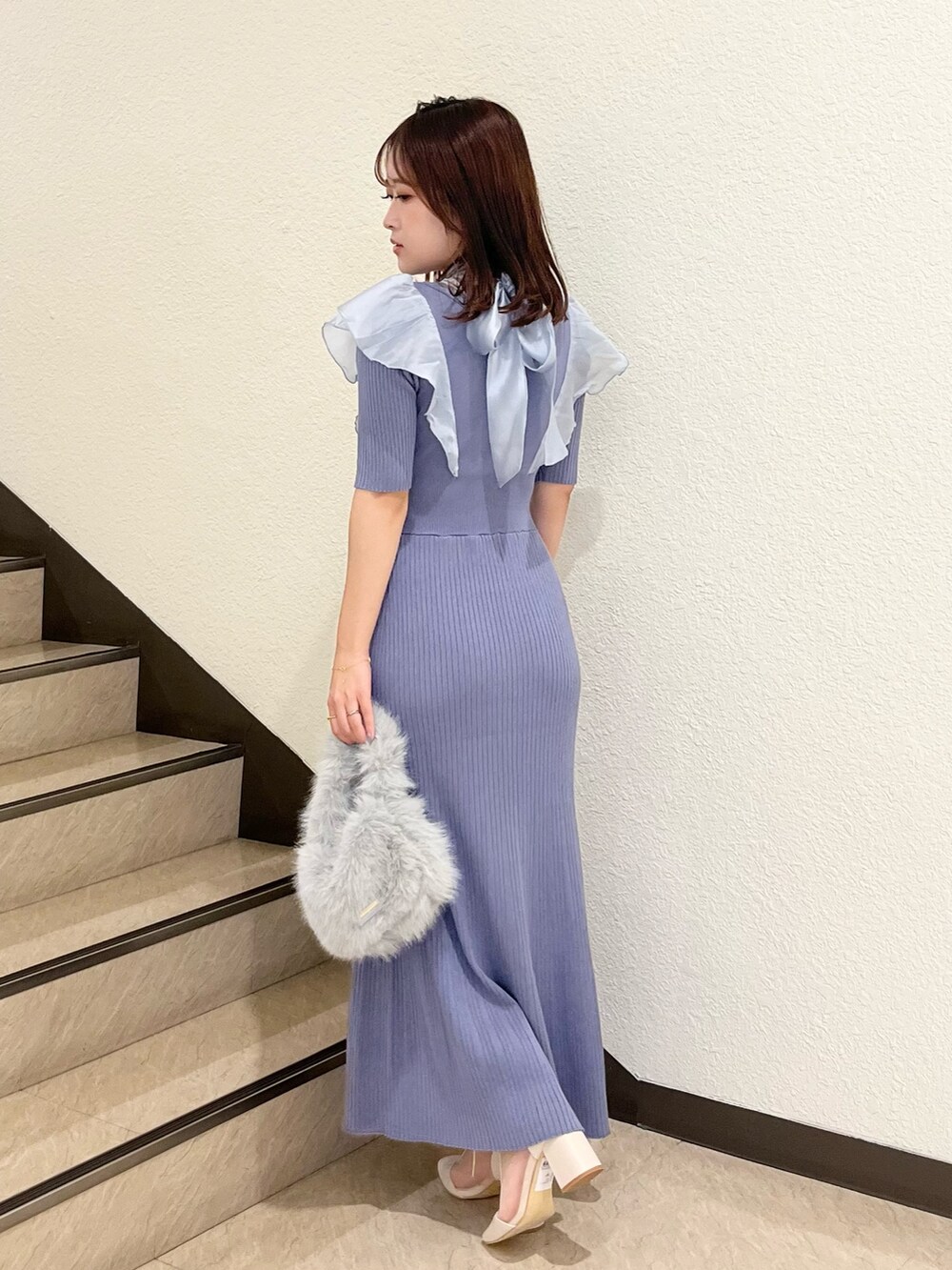 ブルー系のワンピース、グレー系のハンドバッグ、ホワイト系のブーツを着用したレディースの夏コーディネートの3枚目の写真