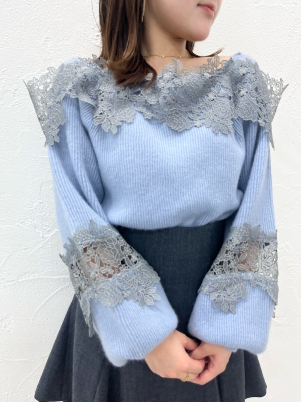 ベージュ系のブーツ、ブラック系のダウンジャケット/コート、ブルー系のニット/セーターを着用したレディースの秋コーディネートの6枚目の写真