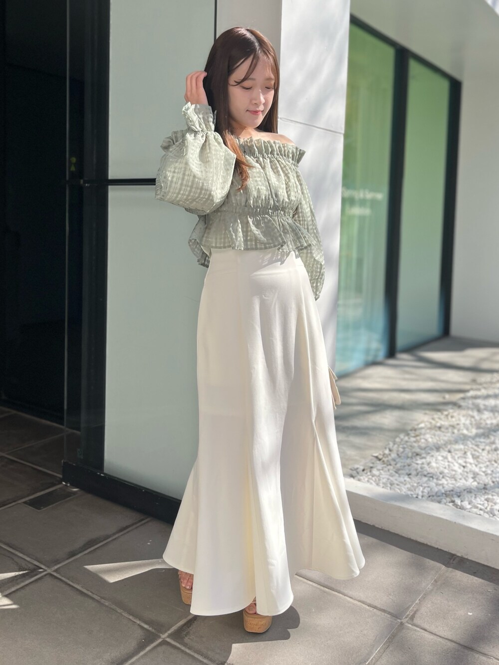 ホワイト系のスカート、グリーン系のシャツ/ブラウス、ベージュ系のショルダーバッグを着用したレディースの冬コーディネートの2枚目の写真