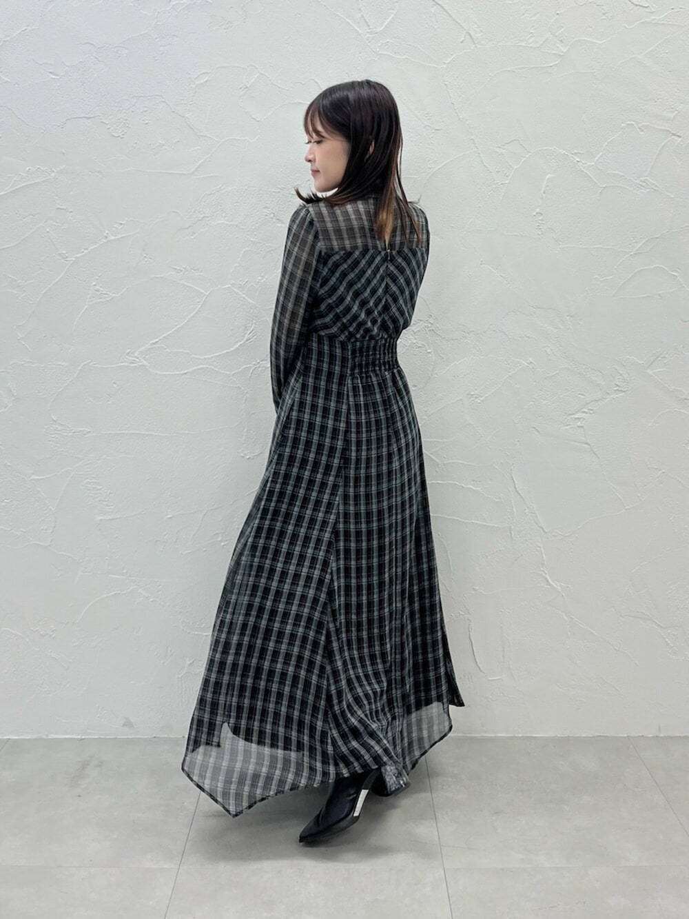 ブラック系のブーツ、ピンク系のカーディガン/ボレロ、ブラック系のワンピースを着用したレディースの秋コーディネートの5枚目の写真