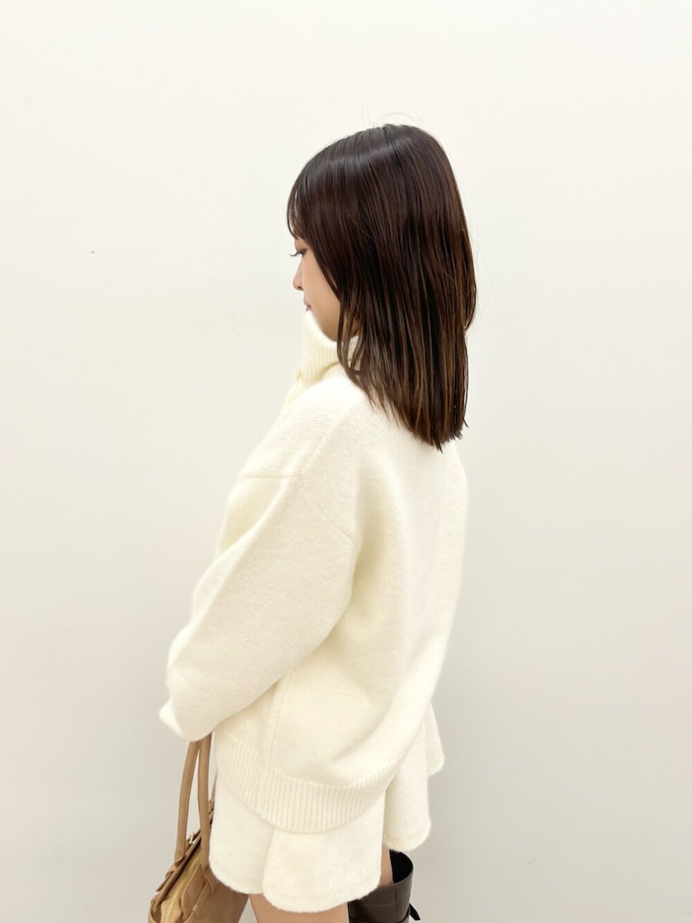 ホワイト系のワンピース、ブラウン系のブーツを着用したレディースの秋コーディネートの5枚目の写真