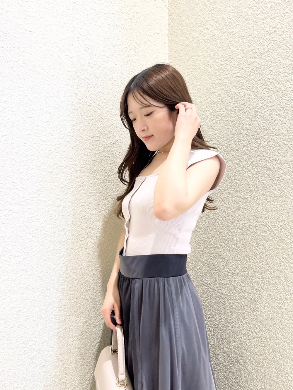 ピンク系のニット/セーター、ブラック系のスカート、ピンク系のショルダーバッグを着用したレディースの春コーディネートの5枚目の写真