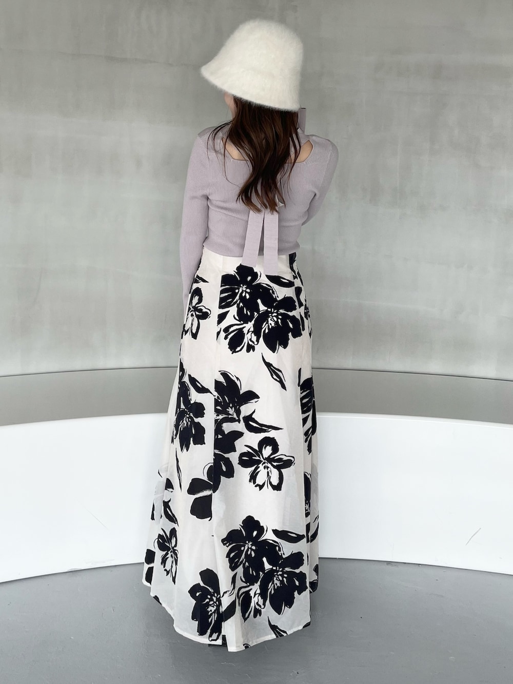 ホワイト系のスカート、パープル系のニット/セーター、ブラック系のブーツを着用したレディースの秋コーディネートの3枚目の写真