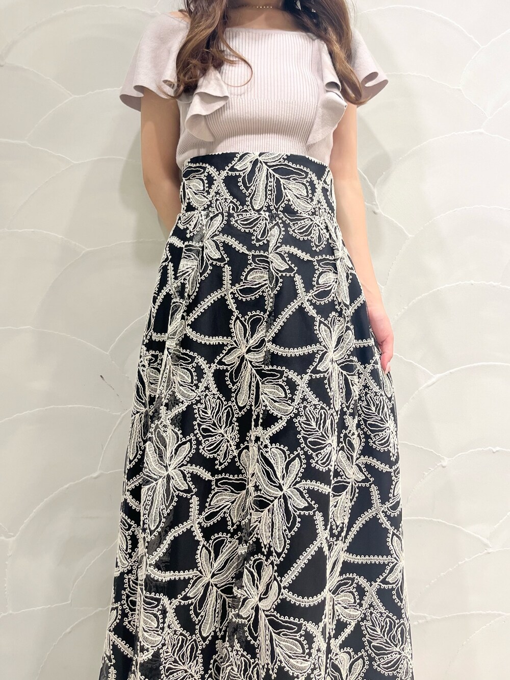 ブラック系のスカート、その他のサンダル、ベージュ系のニット/セーターを着用したレディースの夏コーディネートの4枚目の写真