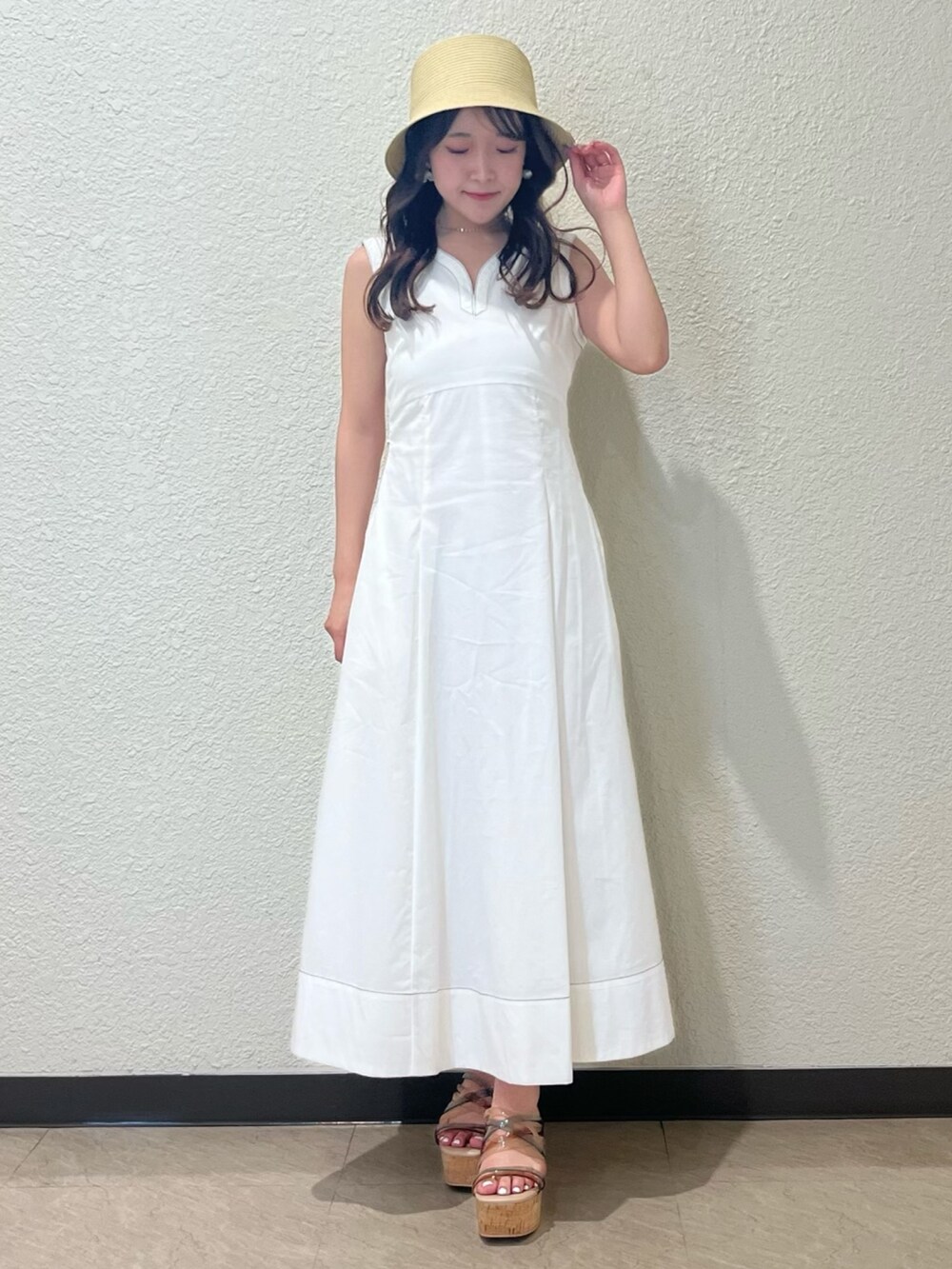 ホワイト系のワンピース、その他のサンダル、ベージュ系のハットを着用したレディースの春コーディネートの6枚目の写真