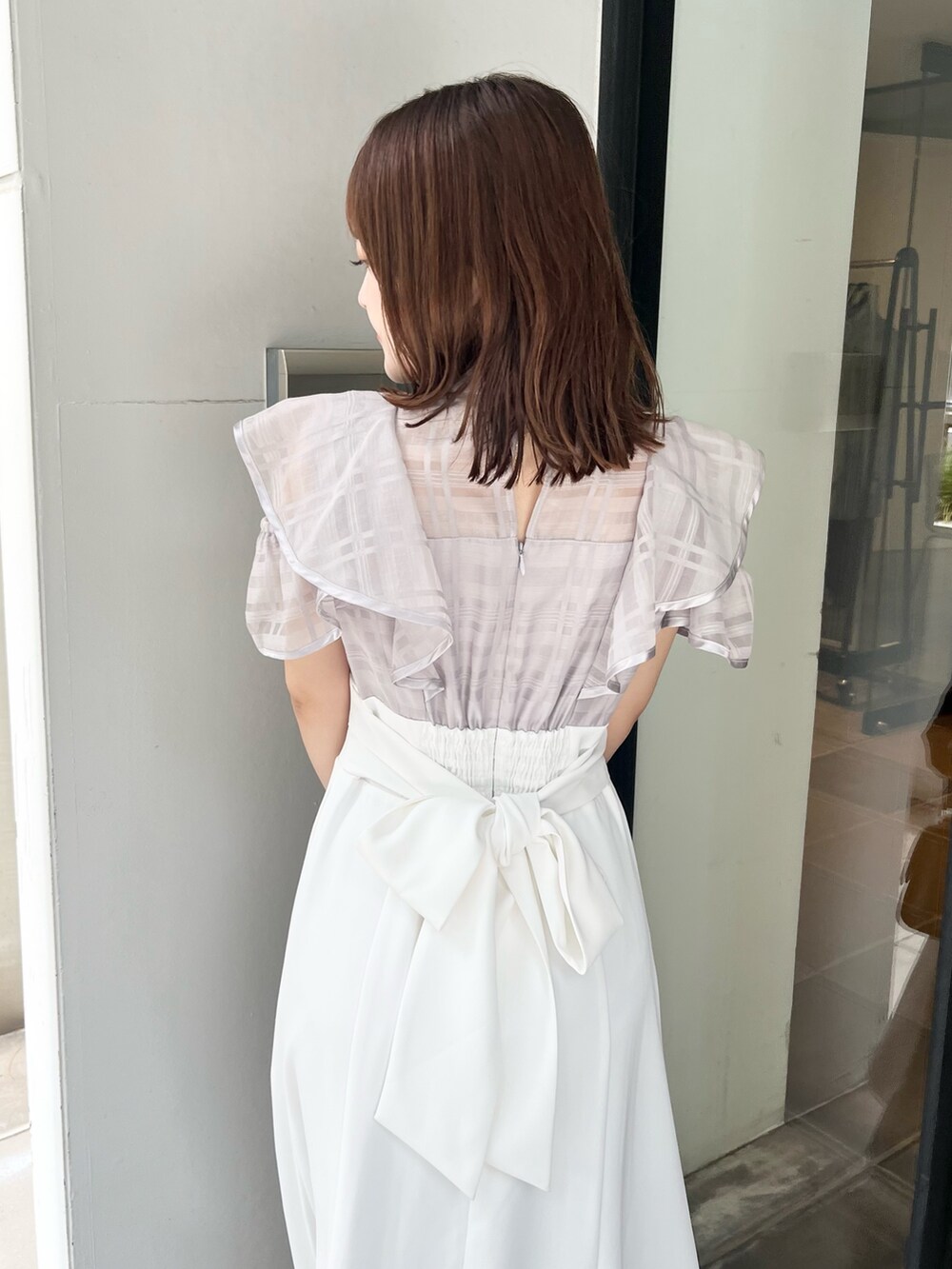 パープル系のワンピース、ブラウン系のサンダル、シルバー系のハンドバッグを着用したレディースの夏コーディネートの6枚目の写真