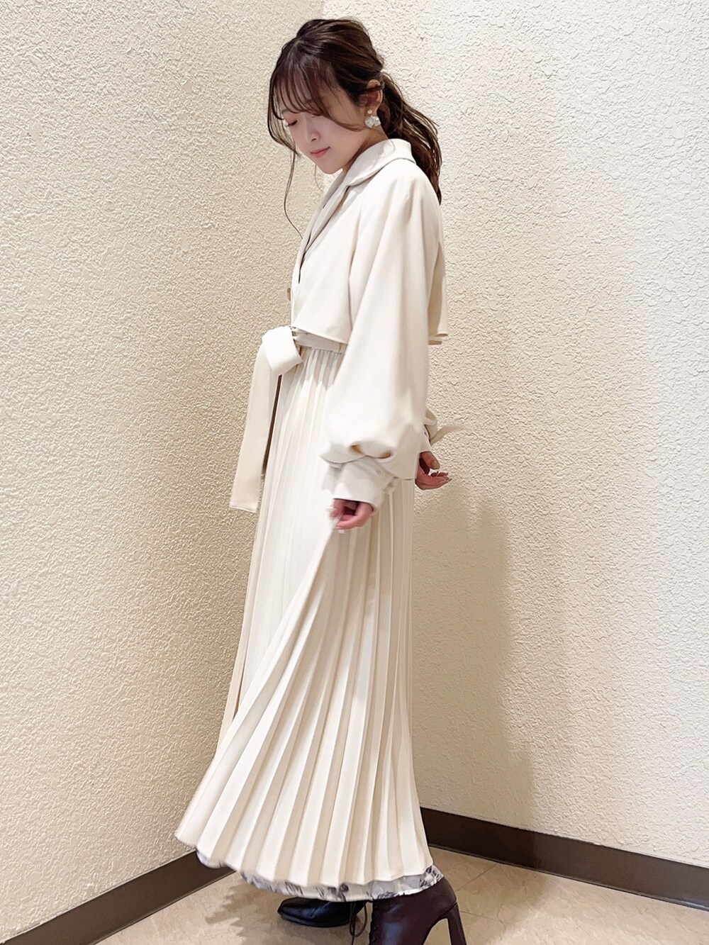 ホワイト系のトレンチコート、ホワイト系のワンピースを着用したレディースの冬コーディネートの7枚目の写真