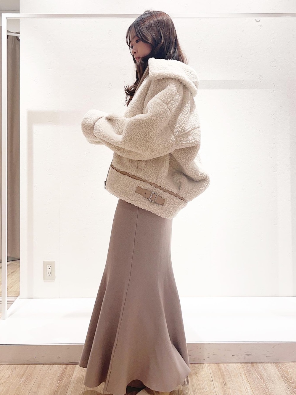 ベージュ系のワンピース、ホワイト系のその他アウター、ホワイト系のブーツを着用したレディースの秋コーディネートの2枚目の写真