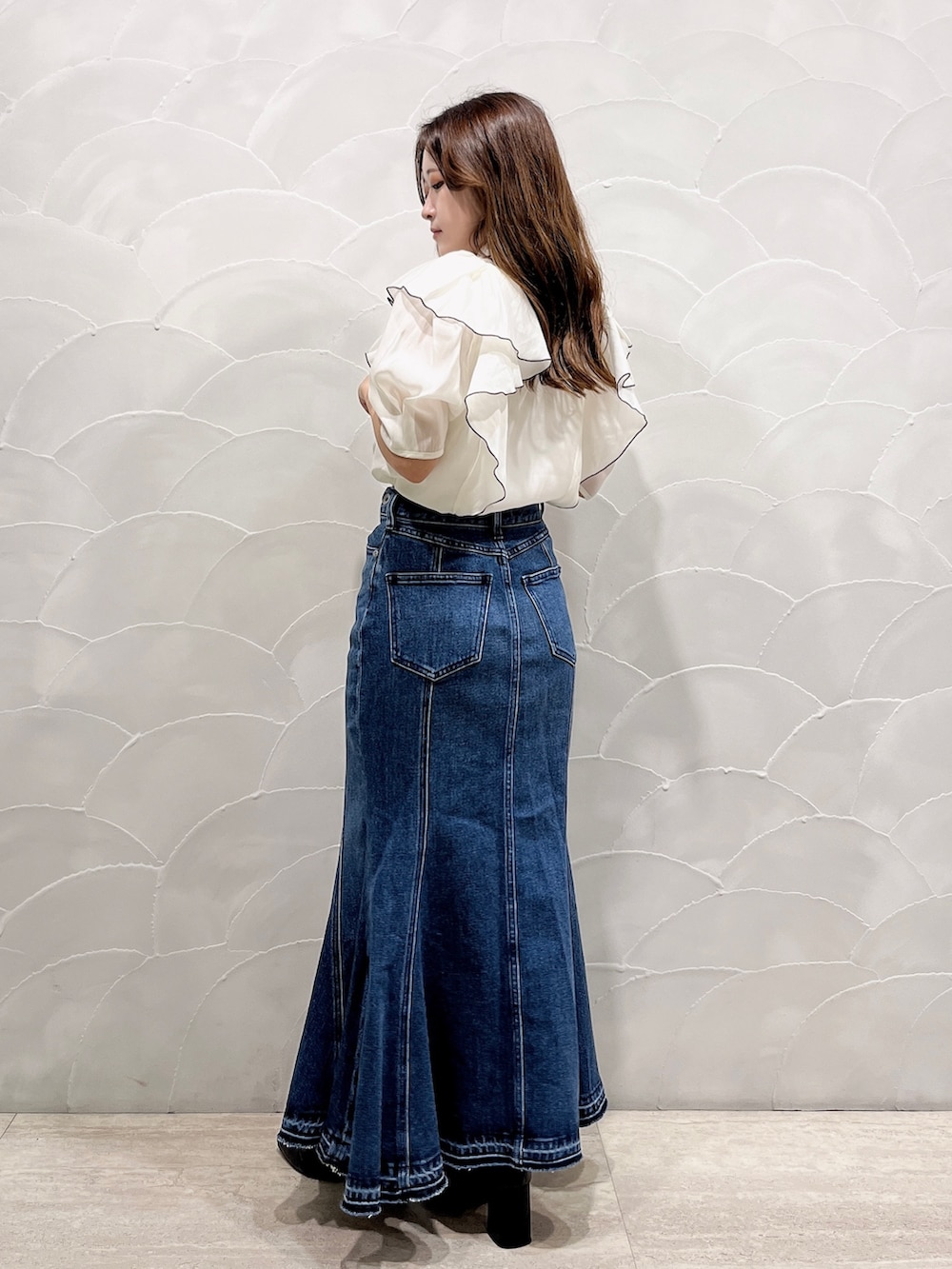 ブルー系のデニムスカート、ホワイト系のシャツ/ブラウスを着用したレディースの夏コーディネートの3枚目の写真