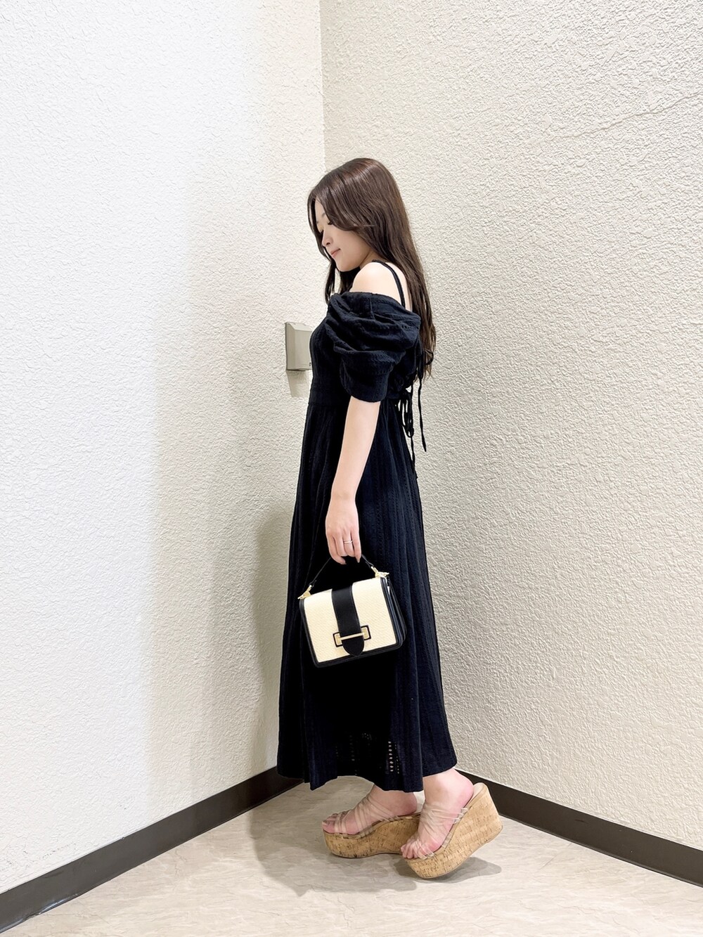 ブラック系のワンピース、その他のサンダル、ブラック系のハンドバッグを着用したレディースの夏コーディネートの2枚目の写真