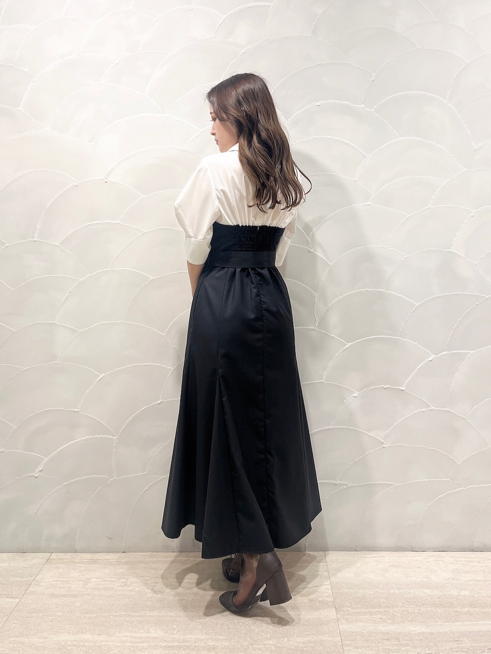 ブラック系のワンピース、レッド系のハンドバッグ、ブラウン系のブーツを着用したレディースの夏コーディネートの3枚目の写真