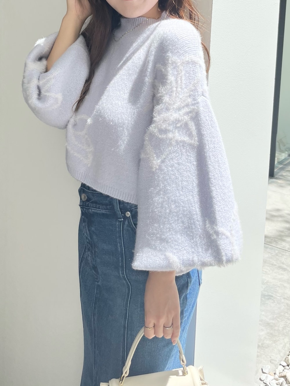 ブルー系のニット/セーター、ブルー系のデニムスカート、ベージュ系のブーツを着用したレディースの秋コーディネートの6枚目の写真