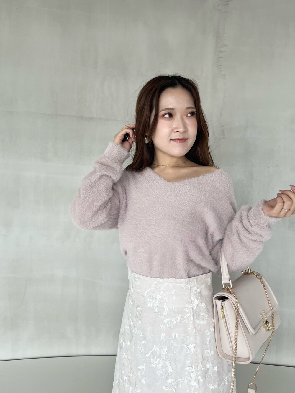 ホワイト系のスカート、ピンク系のニット/セーター、ピンク系のショルダーバッグを着用したレディースの秋コーディネートの4枚目の写真