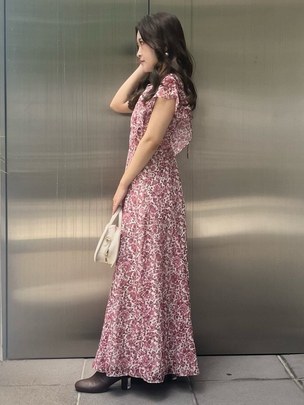 レッド系のワンピース、ホワイト系のハンドバッグを着用したレディースの夏コーディネートの2枚目の写真