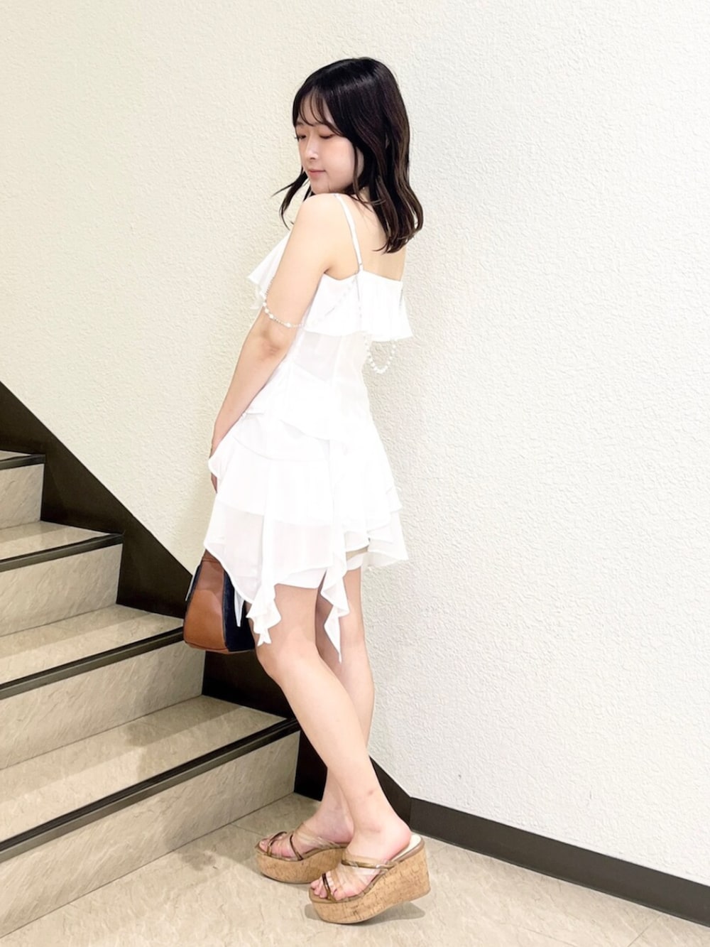 ブラウン系のサンダル、ホワイト系のシャツ/ブラウス、ベージュ系のスカートを着用したレディースの夏コーディネートの2枚目の写真