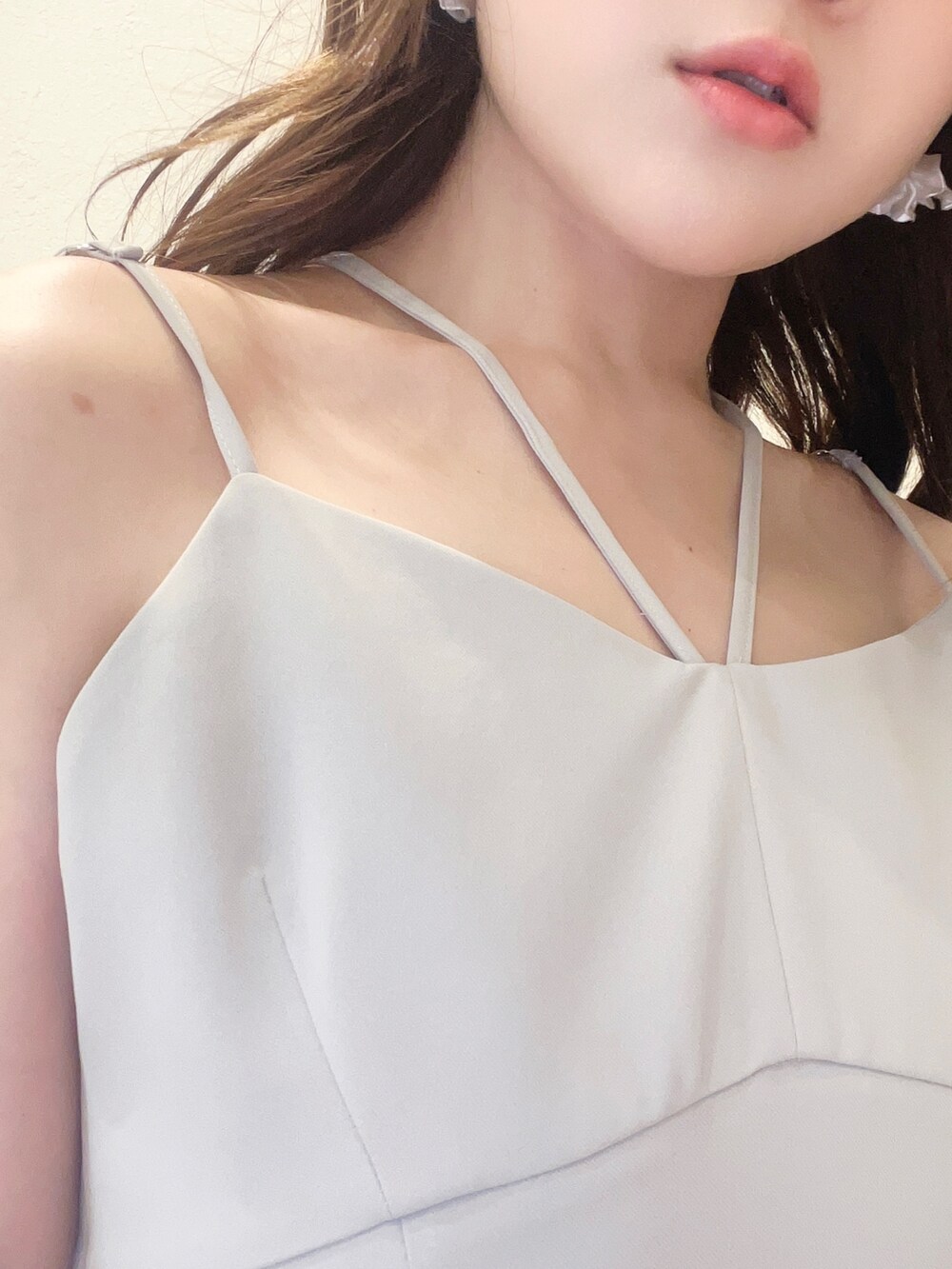 グリーン系のワンピース、ホワイト系のベスト、ブラック系のハンドバッグを着用したレディースの春コーディネートの5枚目の写真