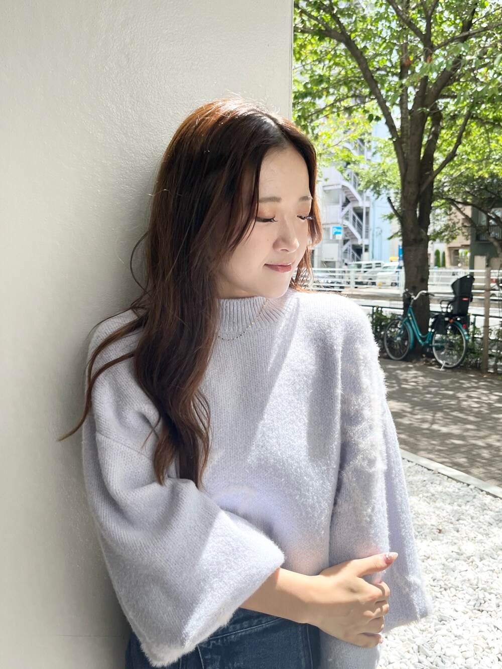 ブルー系のニット/セーター、ブルー系のデニムスカート、ベージュ系のブーツを着用したレディースの秋コーディネートの4枚目の写真