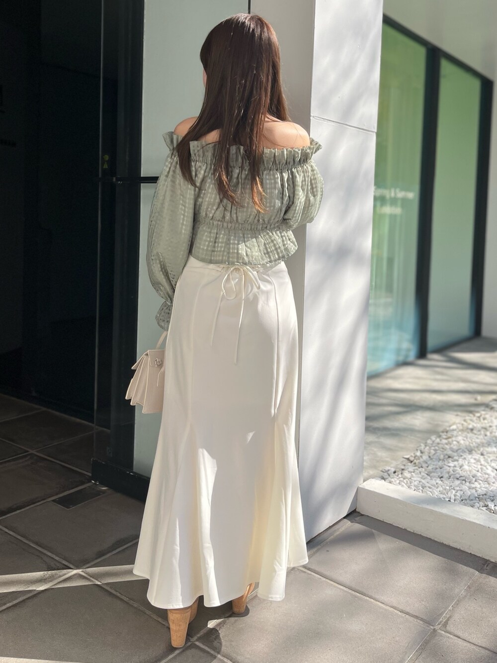 ホワイト系のスカート、グリーン系のシャツ/ブラウス、ベージュ系のショルダーバッグを着用したレディースの冬コーディネートの4枚目の写真