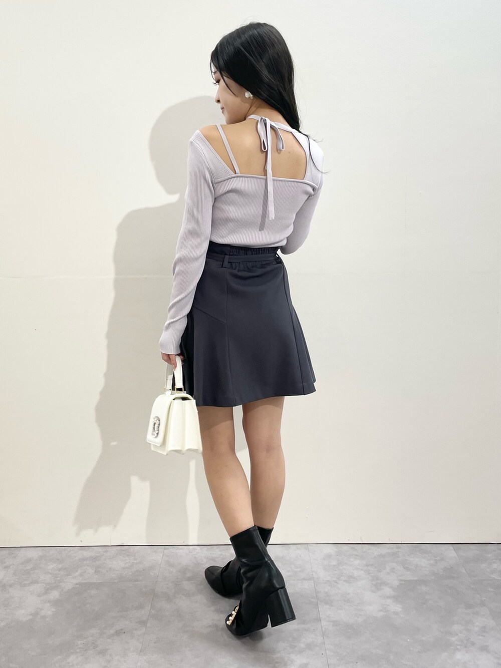 グレー系のその他パンツ、ホワイト系のショルダーバッグ、ブラック系のブーツを着用したレディースの冬コーディネートの2枚目の写真