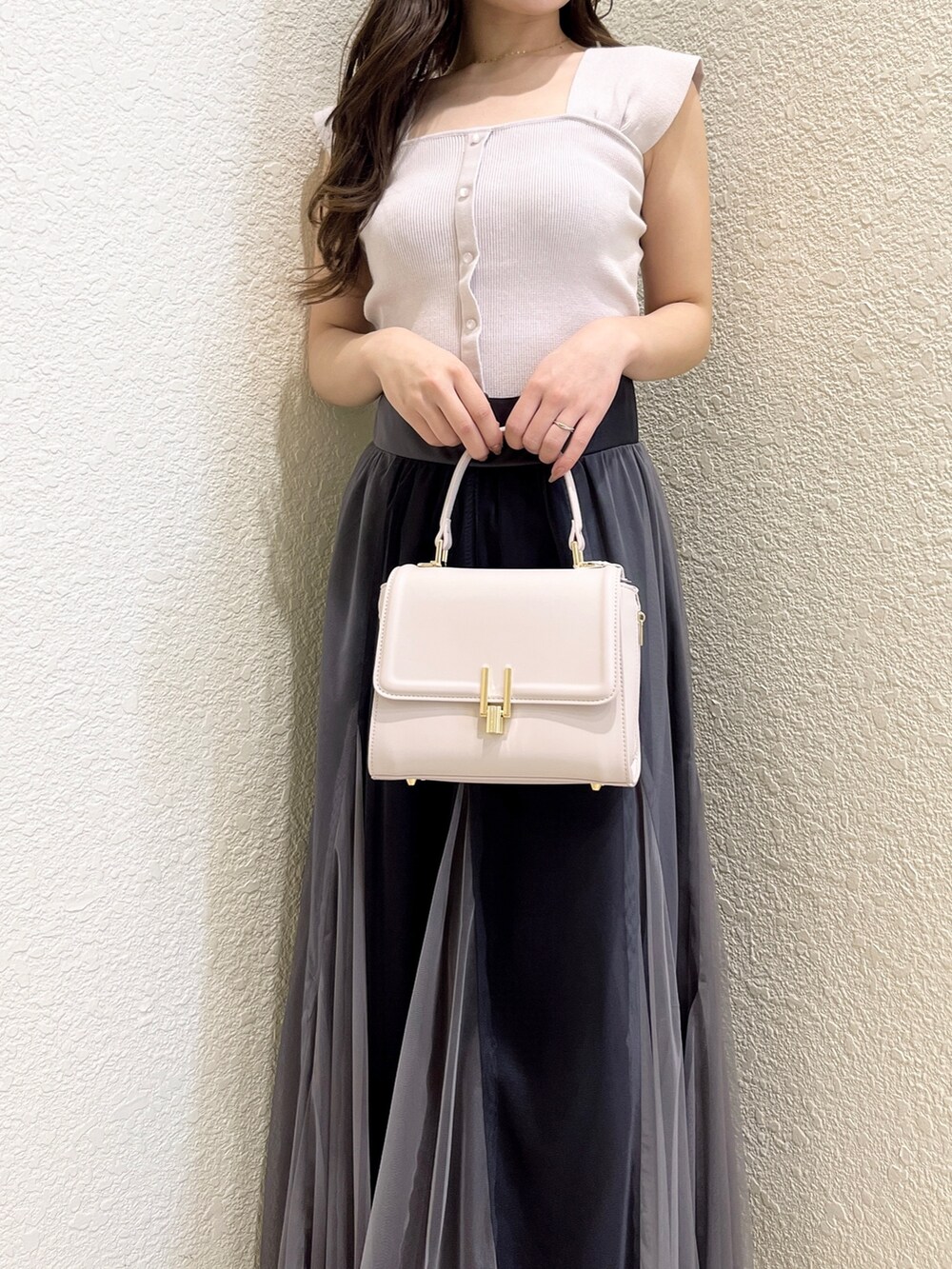 ピンク系のニット/セーター、ブラック系のスカート、ピンク系のショルダーバッグを着用したレディースの春コーディネートの4枚目の写真