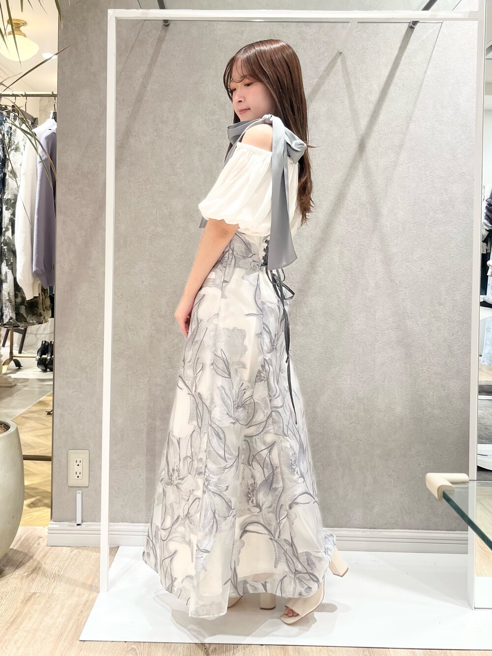 ホワイト系のシャツ/ブラウス、グレー系のスカート、ホワイト系のブーツを着用したレディースの春コーディネートの2枚目の写真