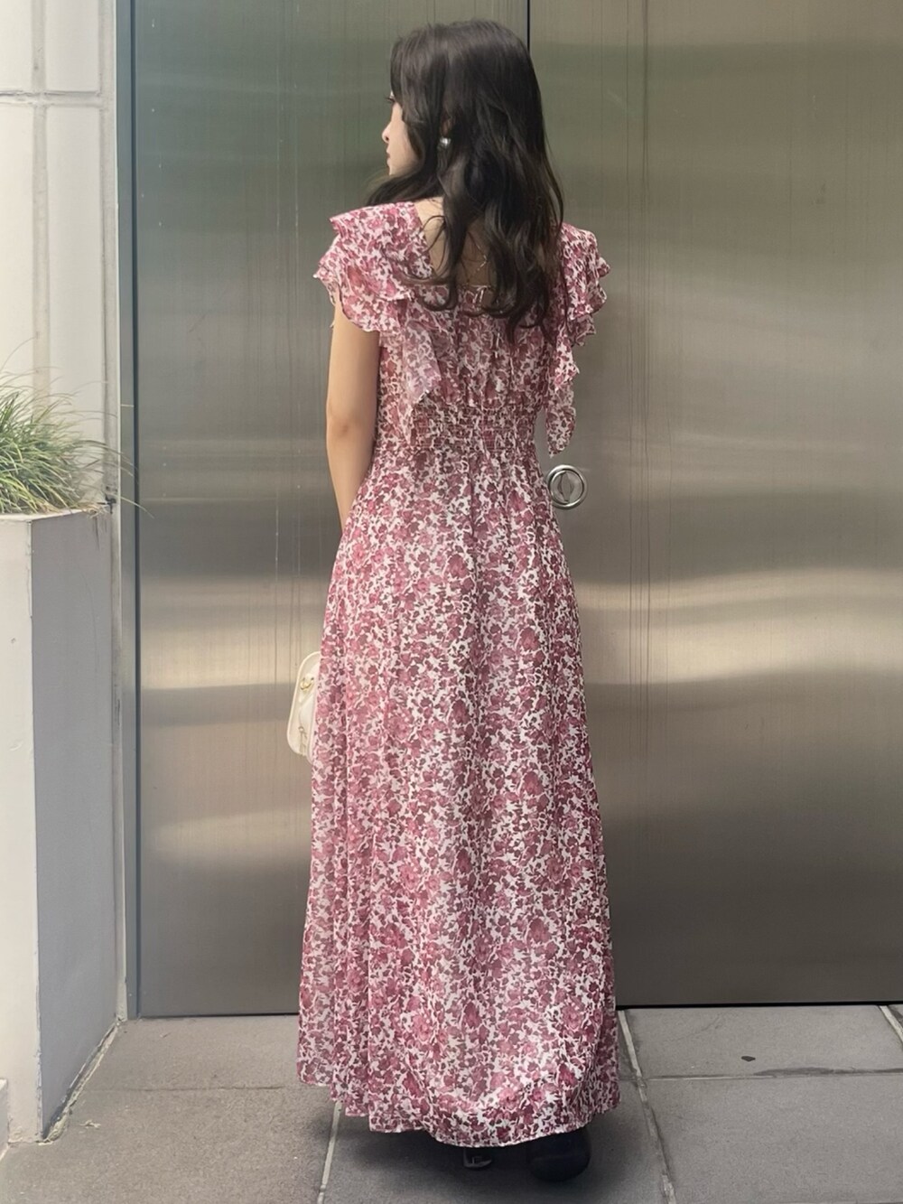 レッド系のワンピース、ホワイト系のハンドバッグを着用したレディースの夏コーディネートの3枚目の写真