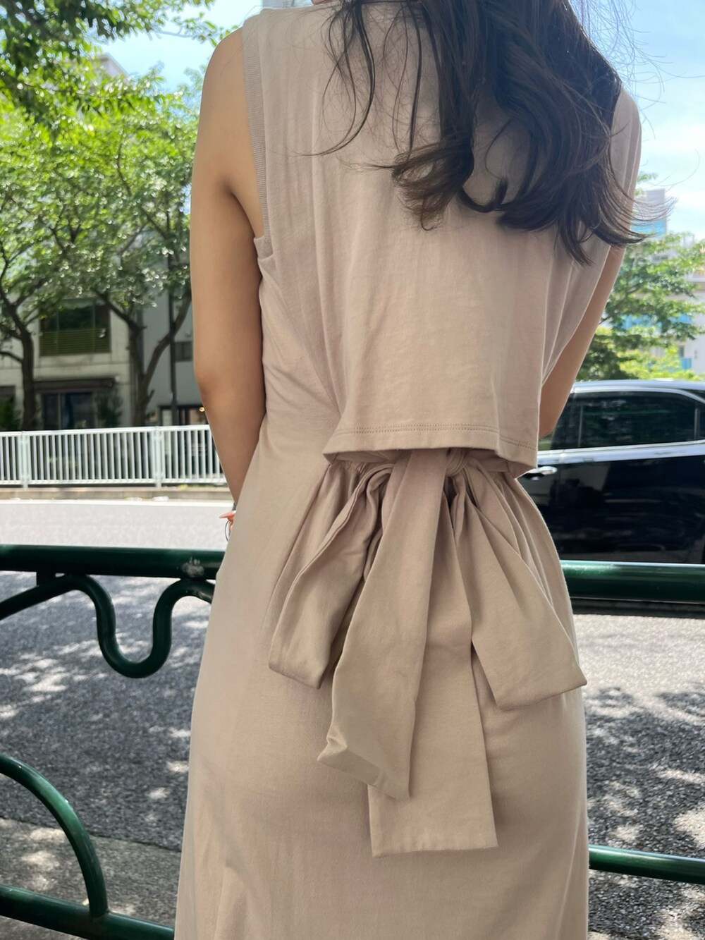 ベージュ系のスニーカー、ベージュ系のワンピース、ベージュ系のキャップを着用したレディースの夏コーディネートの3枚目の写真