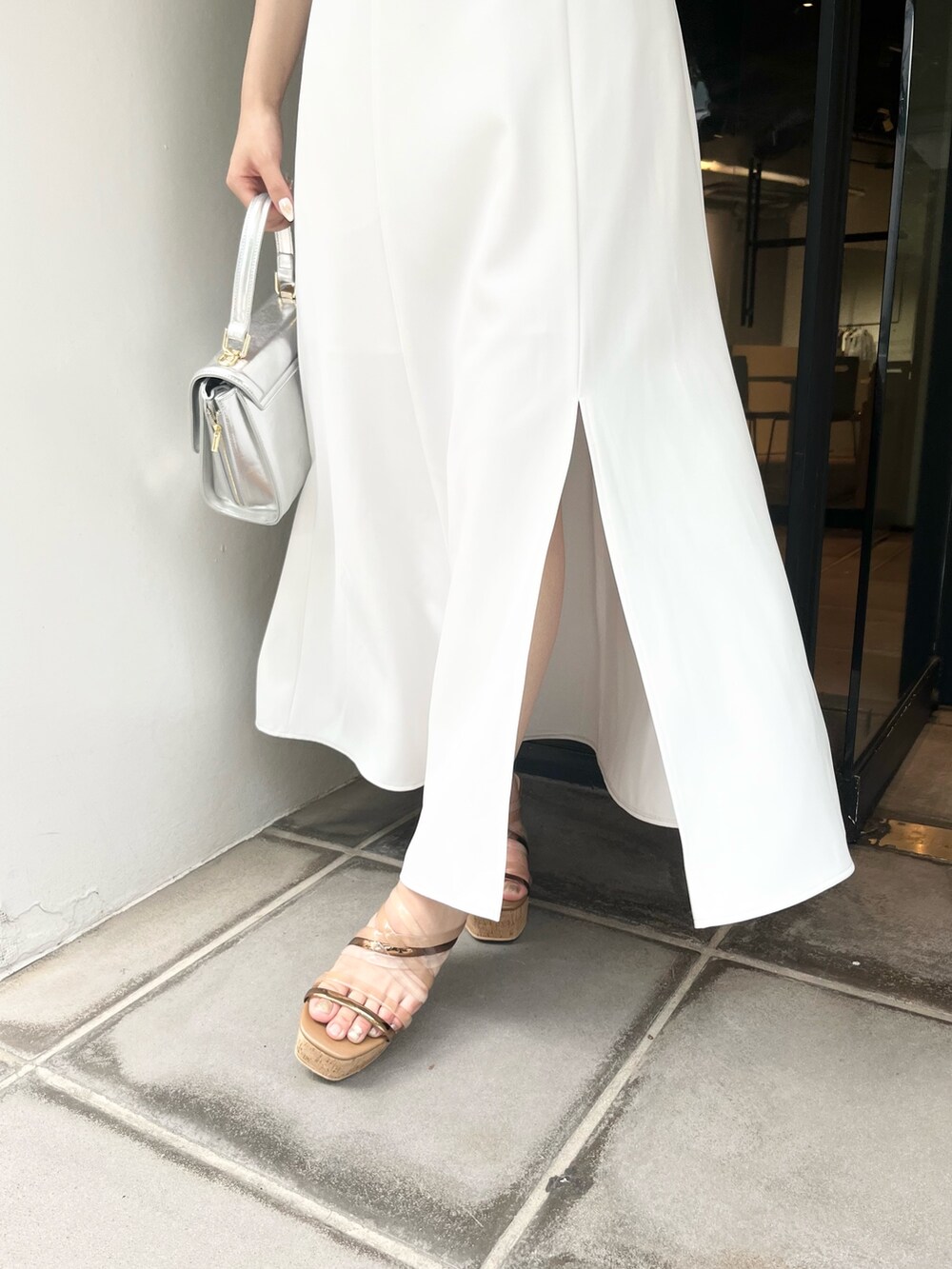 パープル系のワンピース、ブラウン系のサンダル、シルバー系のハンドバッグを着用したレディースの夏コーディネートの7枚目の写真