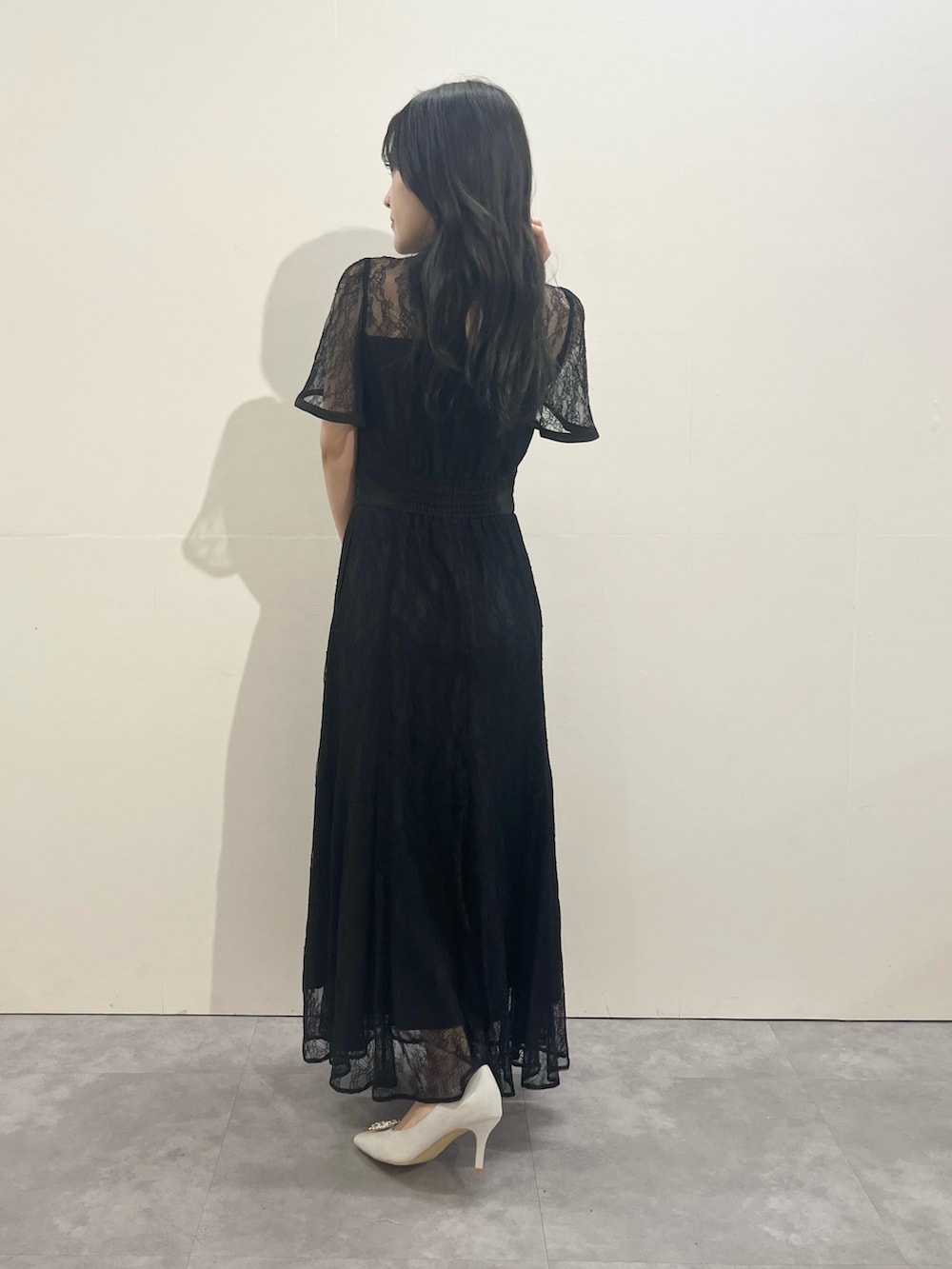 ブラック系のドレス、シルバー系のパンプスを着用したレディースの冬コーディネートの3枚目の写真