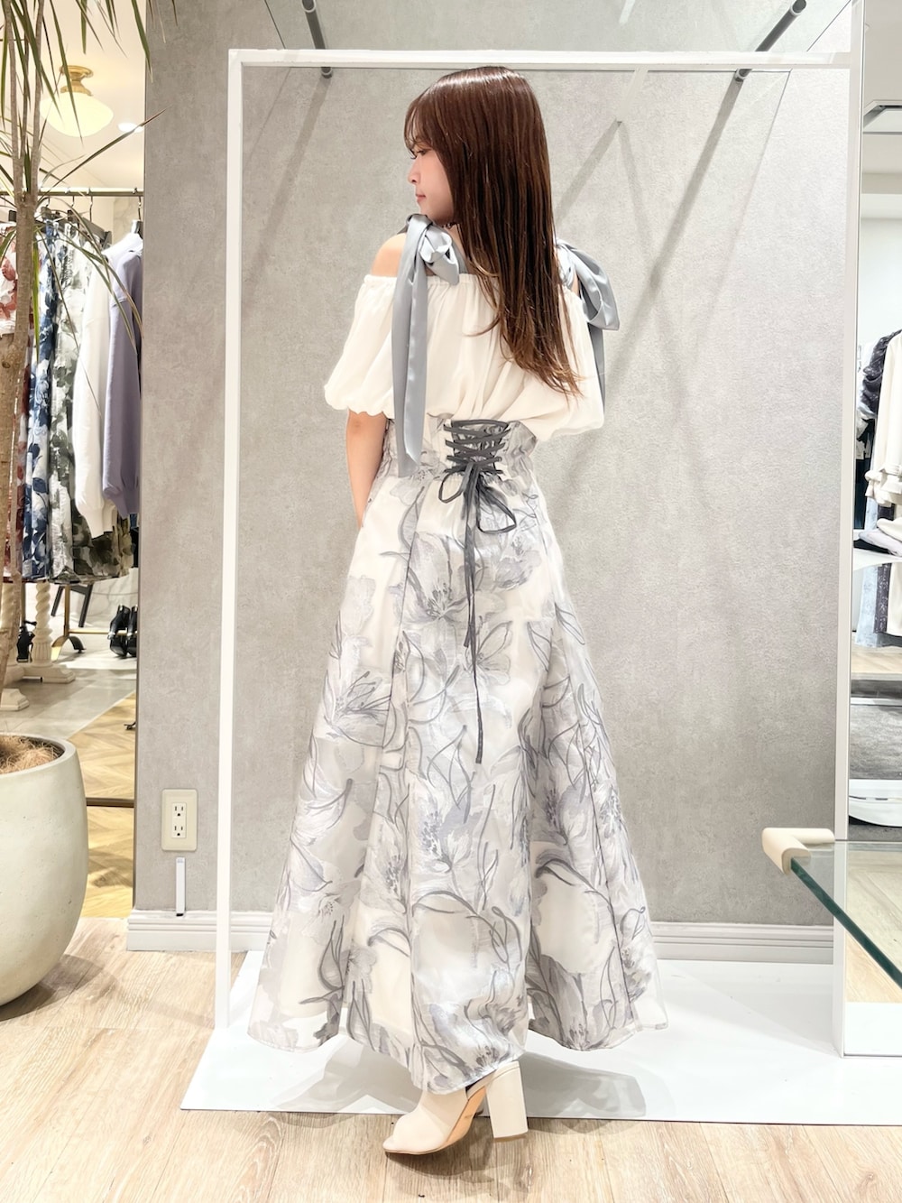 ホワイト系のシャツ/ブラウス、グレー系のスカート、ホワイト系のブーツを着用したレディースの春コーディネートの3枚目の写真