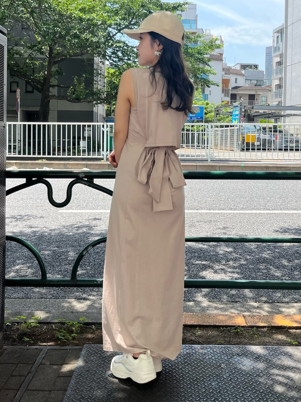 ベージュ系のスニーカー、ベージュ系のワンピース、ベージュ系のキャップを着用したレディースの夏コーディネートの2枚目の写真