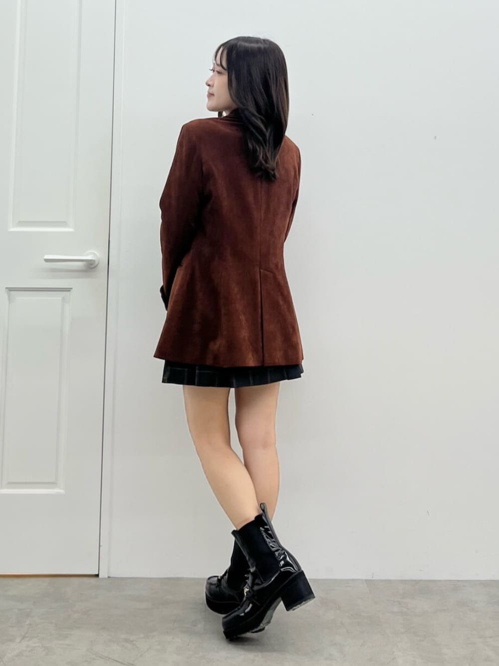 ブラウン系のテーラードジャケット、グリーン系のスカートを着用したレディースの秋コーディネートの3枚目の写真